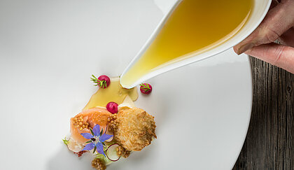 Meal with salmon, mustard and radishes in the toque-awarded restaurant in your sports hotel in Kitzbühel